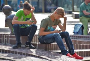 two boys use cell phones